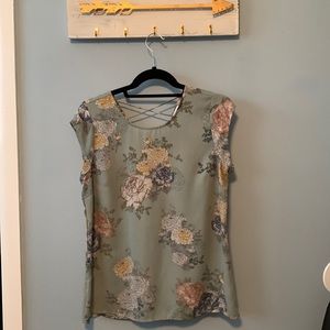 Pretty boutique blouse with floral print and back cross cross design. Size Small